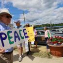 Reverend Daniel Bernier of the Church of the Good Shepherd holds up a sign for peace