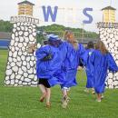 Two graduates skip off into the sunset. 