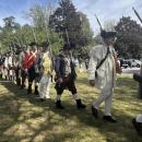 The Minutemen march in traditional clothing during the ceremony.