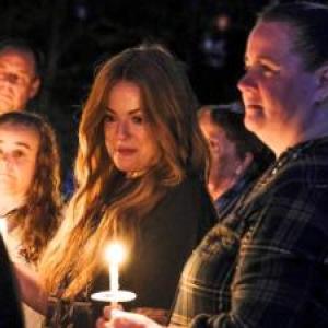 Longtime friends of Nadolny, Kendra Leary, center left, and Shannon Smith, right, look on during the Saturday vigil.
