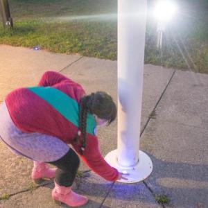 Ainslee Manduca places a light at the flag pole.