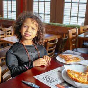 Taking a break from saving the city, Tristan McLean grabs a slice after trick-or-treating. 
