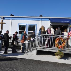 Members file inside the new building.