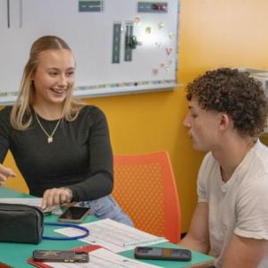 Gloria Jorjakis and Frederic Roy take notes.