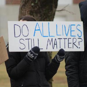 The protest is peaceful with both sides waving signs and chants being called out.