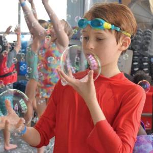 A boy inspects some of the bubbles he caught. 