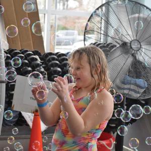 One girl has fun being surrounded by bubbles. 