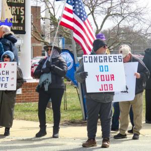 Signs call for Trump's removal and a congressional response to current policy. 