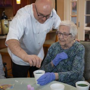 Chef Joe Breda assists resident Claire.