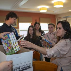 DECA Advisor Lisa Cunha divvies out the supplies.