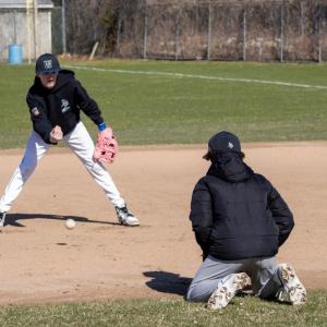 The players focus on catching the ball low.