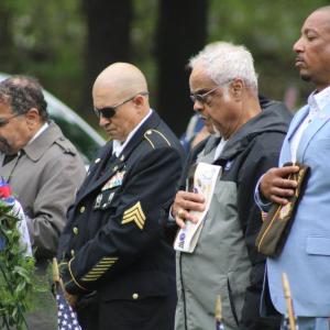 A line of veterans take off their caps during the pledge of allegiance. 