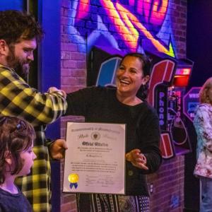 Owner Phill Warren accepts a citation from Kelly Dooner's office. 