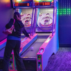 Gamers play skeeball.
