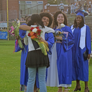 Graduates celebrate with their friend. 