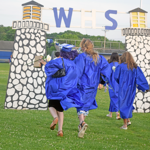 Two graduates skip off into the sunset. 