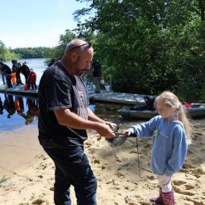 John Krystofolski, left, helps Kyla Stecchi, 5, to hold a fish.