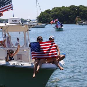 Two hold flag at front of boat