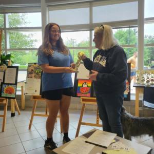 Kailyn Ostiguy gets her trophy from contest organizer Sally Morrison.