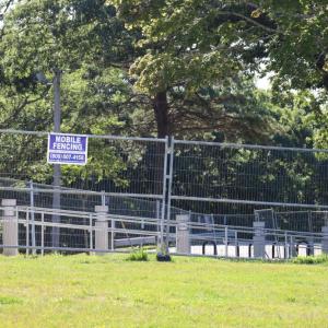 Fabricated metal fencing, a possible final touch on the project,  sits behind construction barricades. 