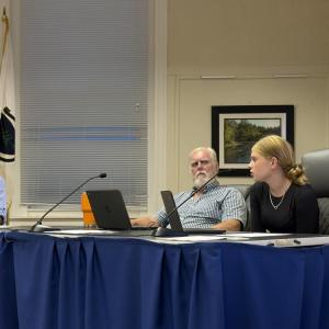 Student representative Emily Brundage, right, tells School Committee Chair Geoffrey Swett, left, and member Roger Bonin, center, about the updated digital hall pass system. Photo by Christian Uva