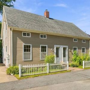 Front of the duplex at 17 Beeden Road in Westport, MA, with a white picket fence and double front doors
