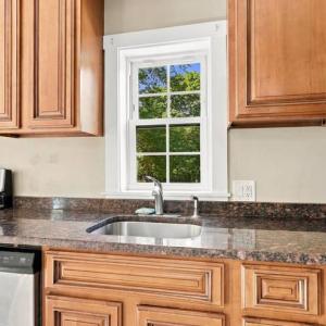 Kitchen sink under a window with granite counters at 17 Beeden Road in Westport, MA