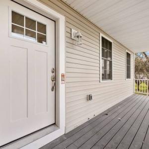 Covered front porch with a white entry door and gray decking at 441 Old County Road in Westport, MA, recently sold