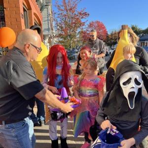 Costumed children take candy from a sombrero-shaped dish outside El Mariachi. 