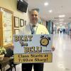Wareham High School Principal Scott Palladino holds a sign reminding students to get to class before the morning bell. Photo by Grace Roche