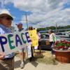 Reverend Daniel Bernier of the Church of the Good Shepherd holds up a sign for peace