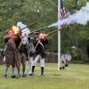 The Minutemen and Militia shoot guns dressed in period clothing.
